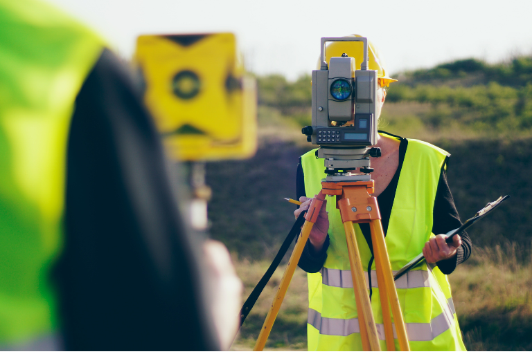 Two surveyors setting up total stations